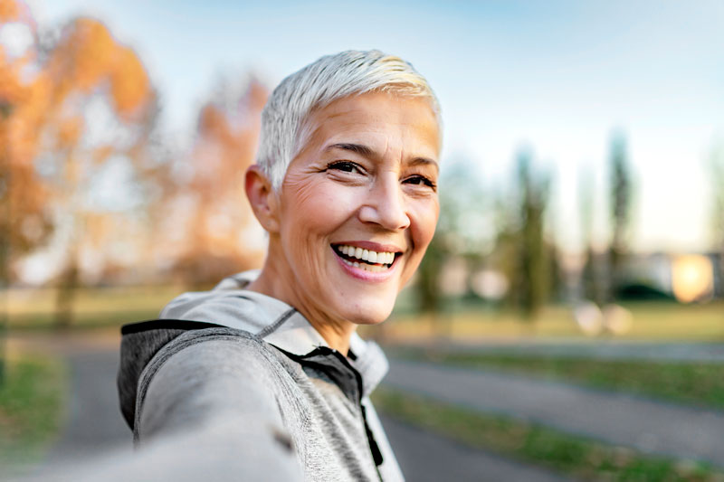 women with short hair smiling while on her walk showing her great smile