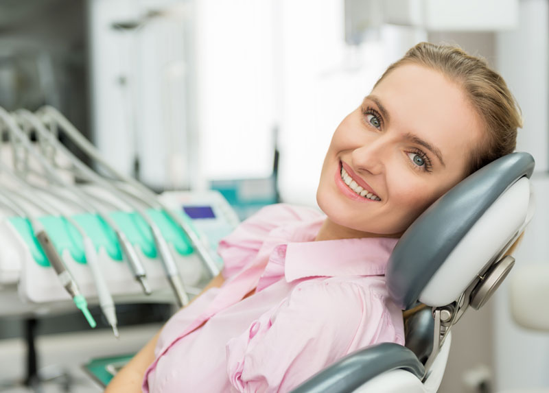 women smiling calmly in a dental chair